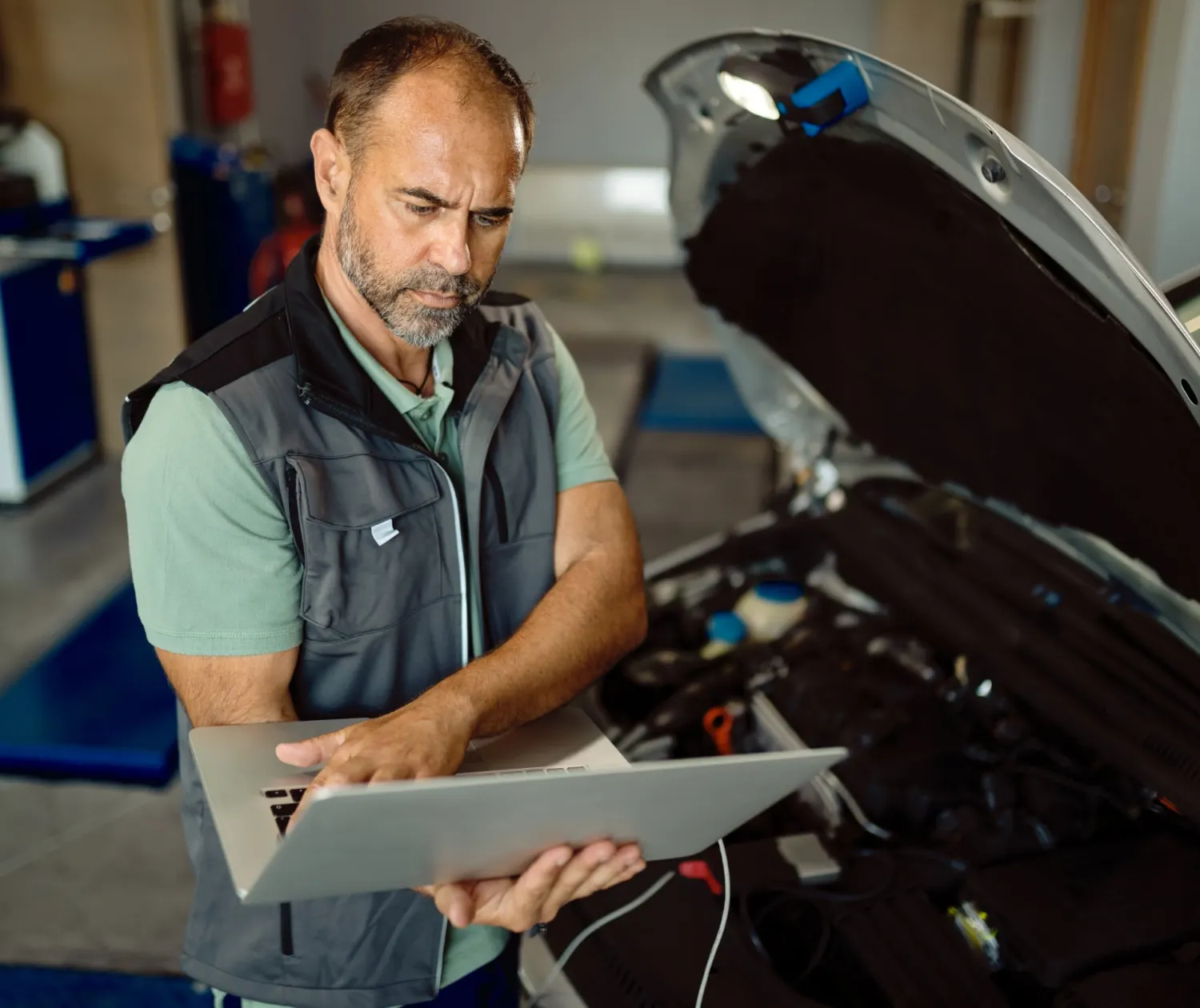 Mecânico usando notebook para diagnóstico eletrônico do motor